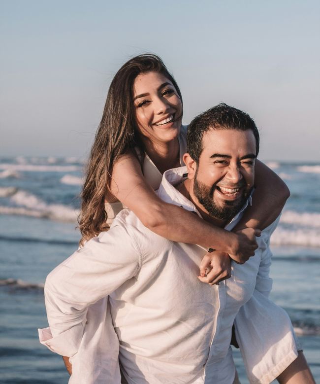 Couple souriant sur la plage, voyage en couple sur mesure